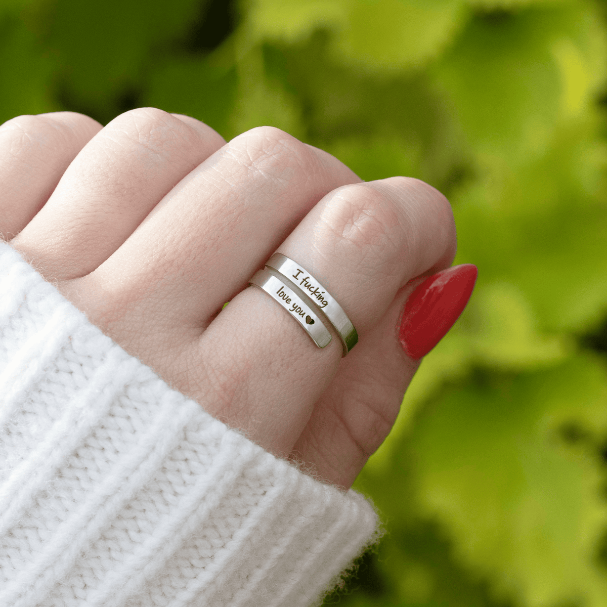 Adjustable ring worn on the finger, engraving visible